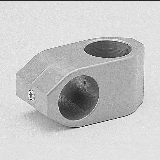 A robust, silver-coloured cross connector made from raw aluminium by Swissclamp, featuring two cylindrical holes running perpendicular to one another for 25mm tubes. A small Allen screw for fastening is visible at one end.