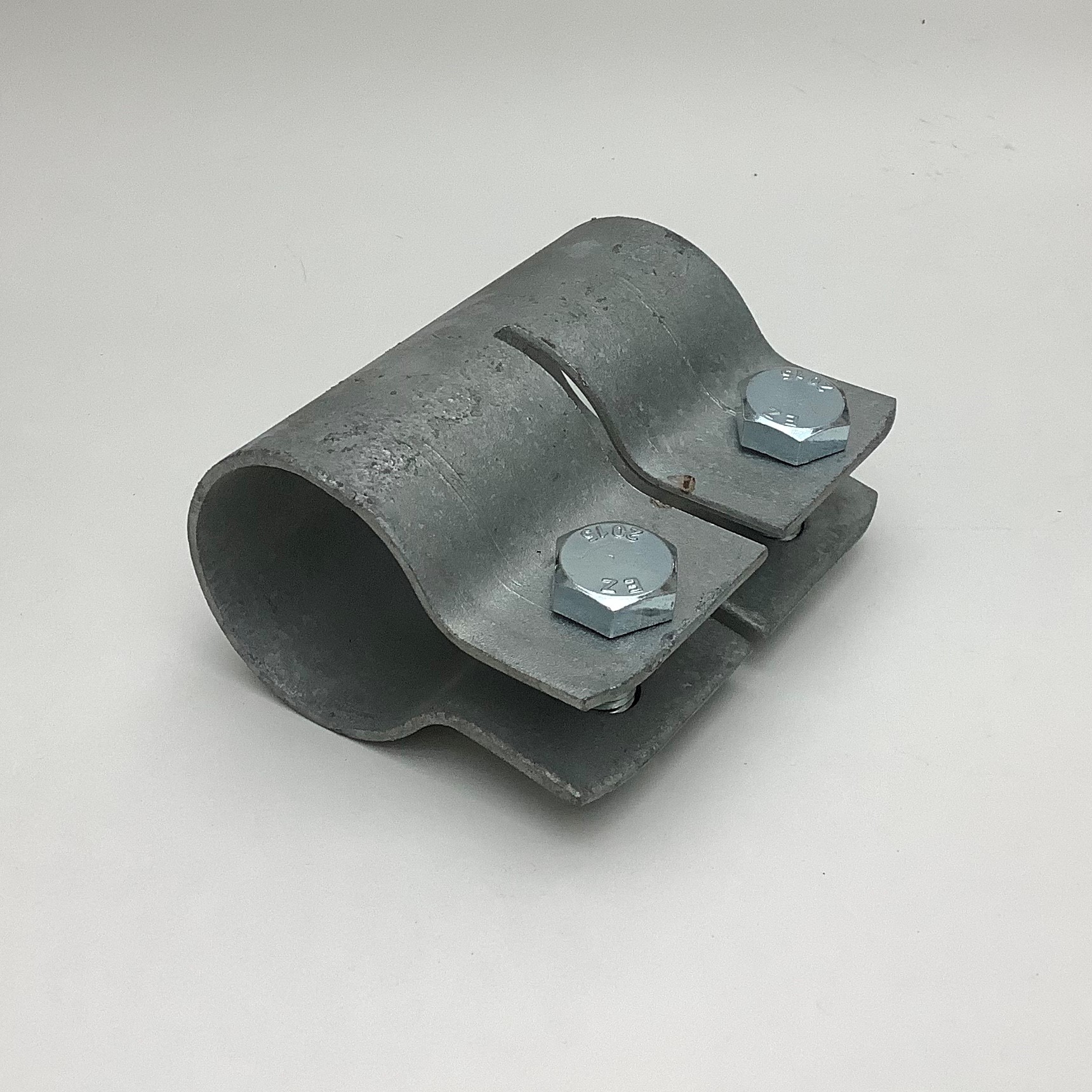 Verzinkte Rohraussenverlängerung aus zwei halbkreisförmigen Metallschalen, fest verbunden mit zwei silbernen M10 Schrauben und Muttern. Matte, leicht strukturierte Oberfläche typisch für verzinkten Stahl, für 42.4 mm Rohre.