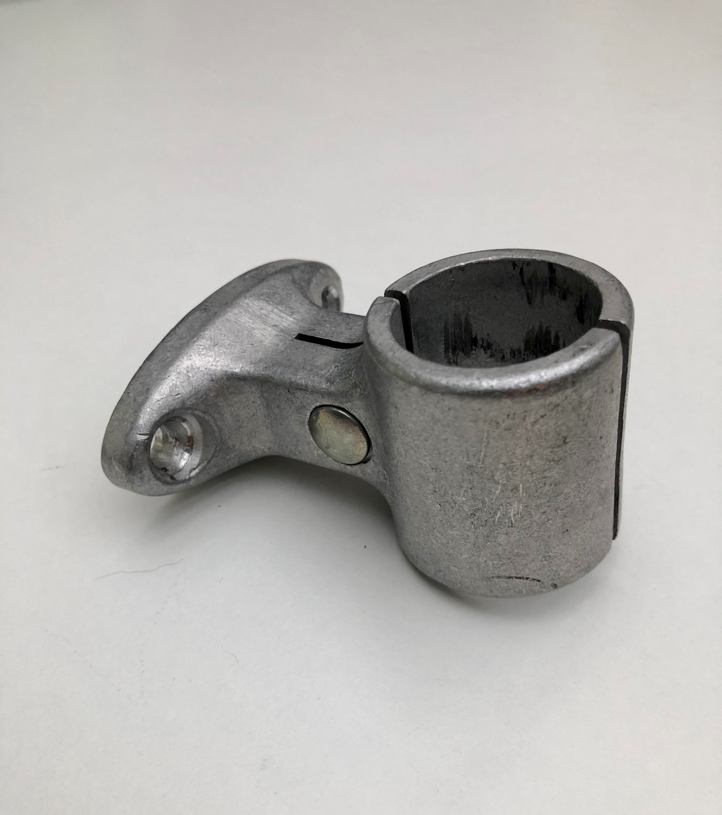 Graue, rohe Aluminium-Mittelstütze von Swissclamp, seitlich auf hellem Hintergrund. Mit zylindrischer Klemmöffnung (30mm) und seitlicher Klemmschraube zur Befestigung. Oberfläche matt, leicht strukturiert.